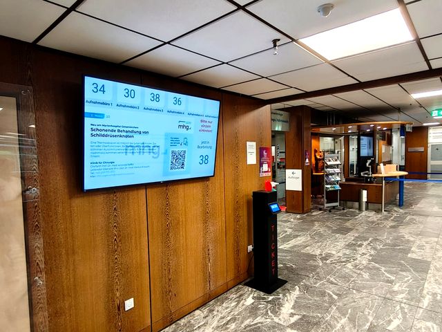 Display und Ticketsäule im Aufnahmebereich des Marienhospitals Gelsenkirchen, das Display zeigt die aufgerufenen Nummern für fünf Aufnahmeräume